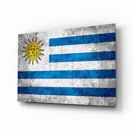 Uruguayan flag glass wall art displayed at an angle, showing blue and white horizontal stripes with a yellow sun symbol, against a white background.