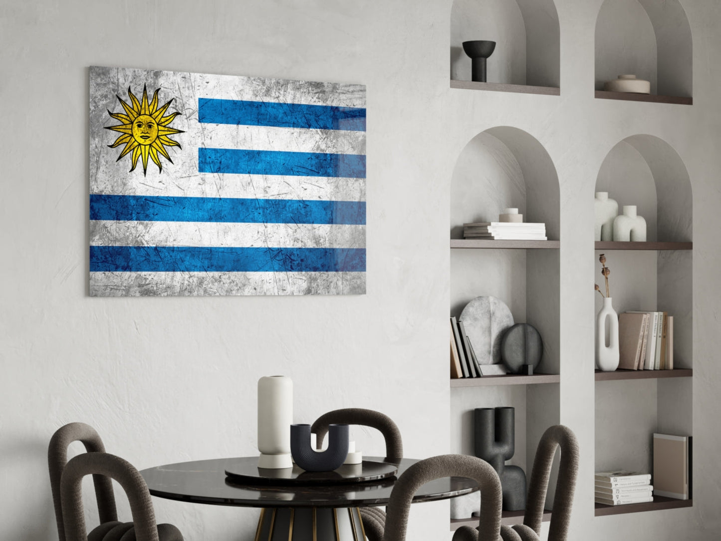 Uruguayan flag glass wall art with blue and white stripes and yellow sun displayed above a black round dining table with grey chairs.