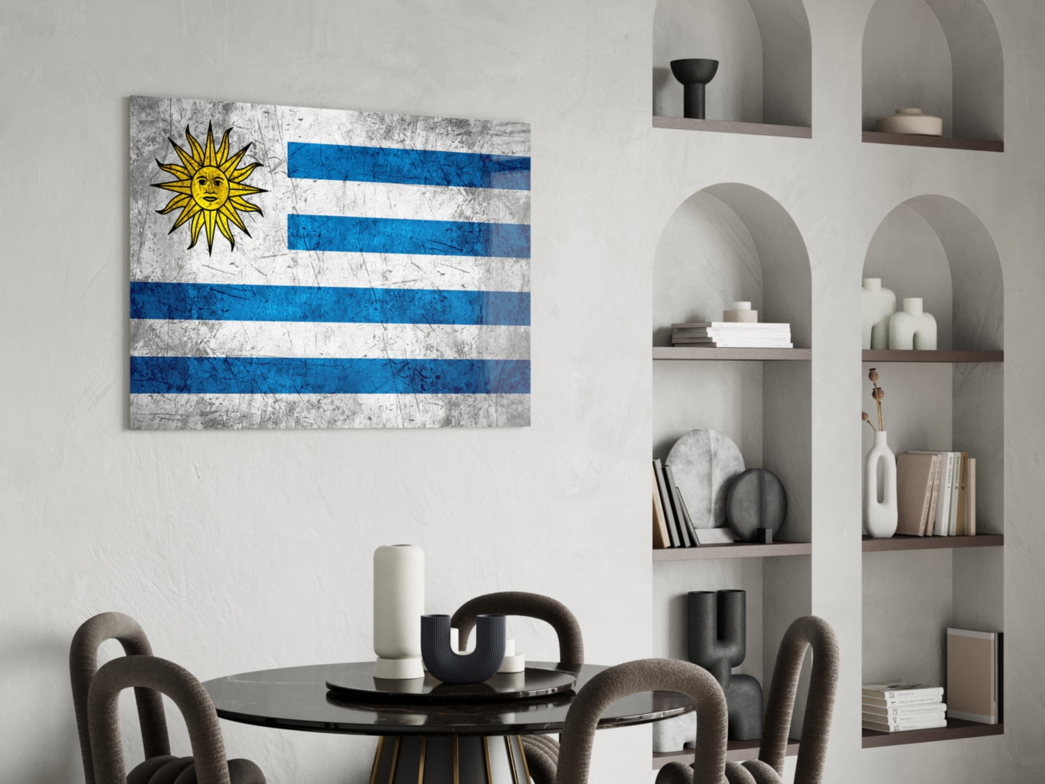 Uruguayan flag glass wall art with blue and white stripes and yellow sun displayed above a black round dining table with grey chairs.