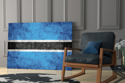 Botswana flag glass wall art displaying blue, white, and black horizontal stripes displayed in modern living room interior.