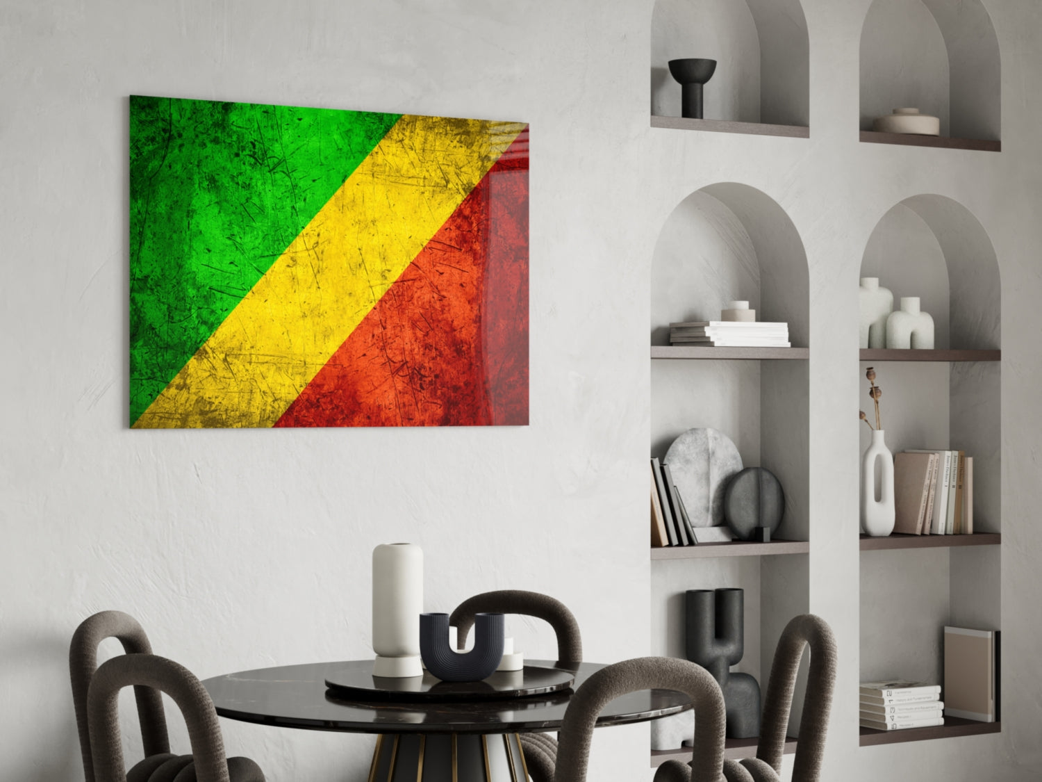Glass wall art displaying the Republic of the Congo flag with green, yellow, and red diagonal stripes, hung above a black dining table with chairs.