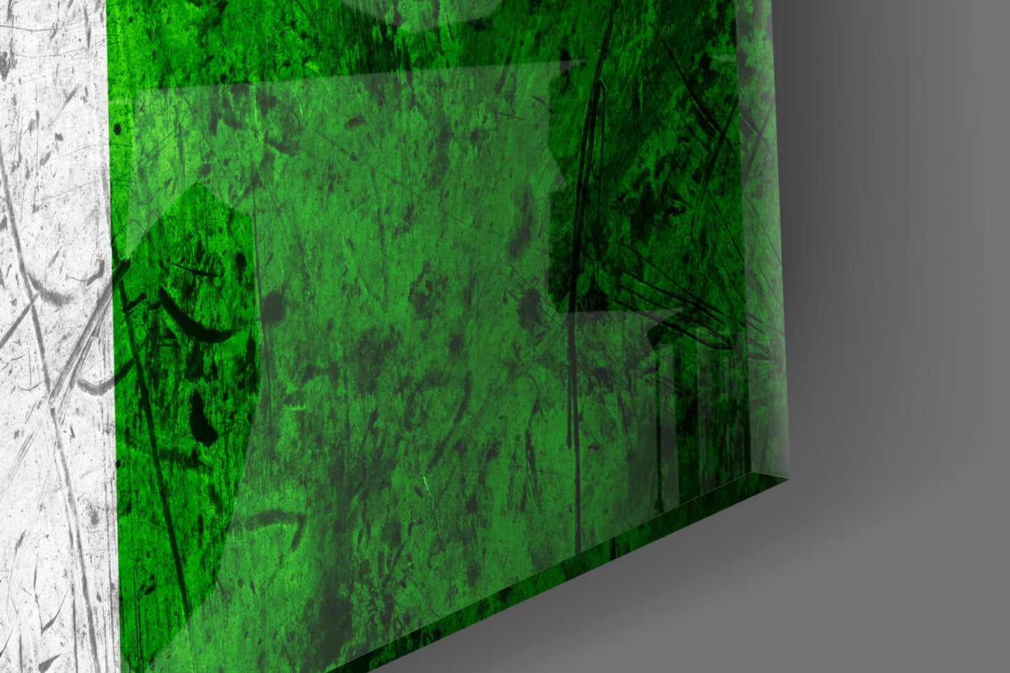 Close-up angled view of green glass panel with black scratches and marks, white edge visible on left side.