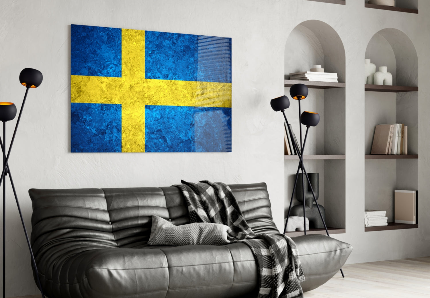Swedish flag glass wall art in blue and yellow hanging above a black leather sofa in a modern living room interior.