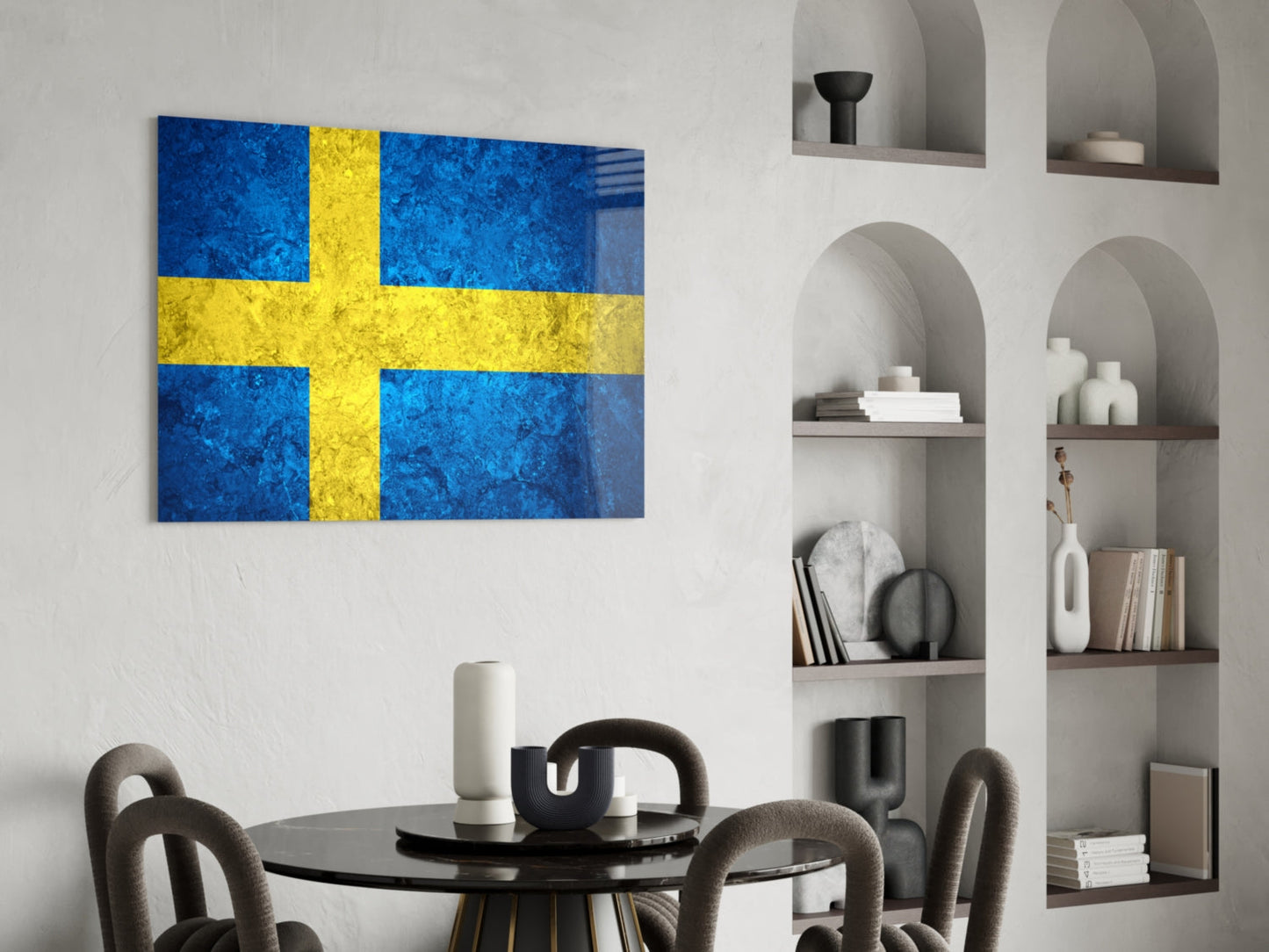 Swedish flag glass wall art with blue and yellow cross displayed above round black dining table in modern interior.