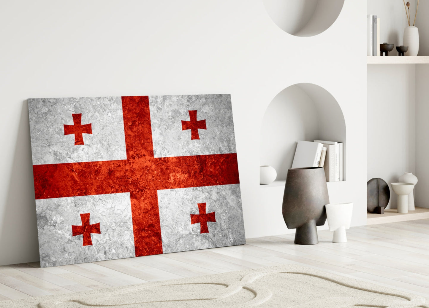 Georgian flag glass wall art leaning against white wall in minimalist interior with decorative objects and shelving.