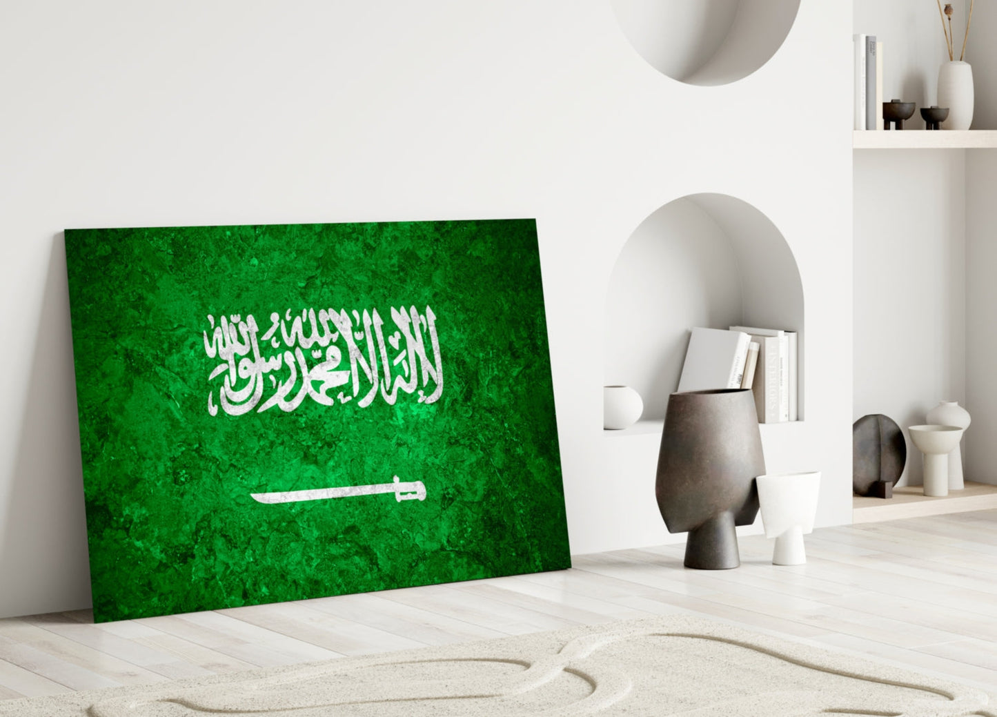 Green glass panel with white Arabic calligraphy and sword symbol leaning against white wall in minimalist interior setting.
