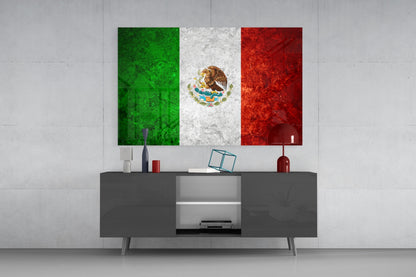 Mexican flag glass wall art with green, white, and red vertical stripes and golden eagle emblem displayed above modern gray media console.