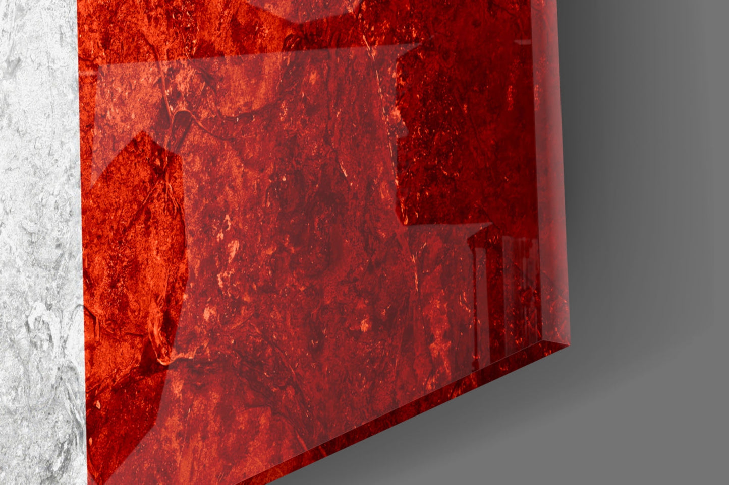 Close-up angled view of red textured glass wall art with white concrete wall edge visible on left side.