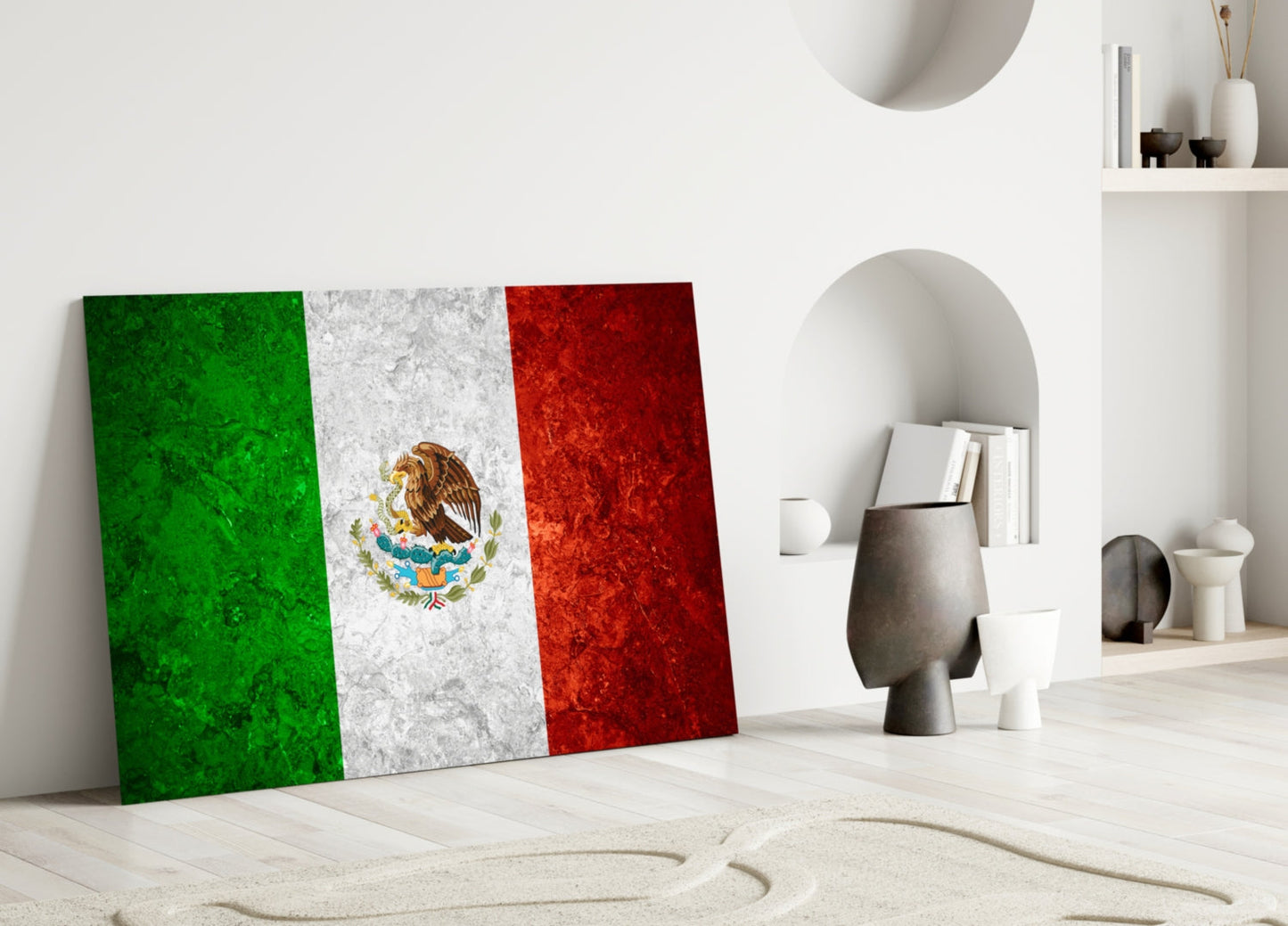 Mexican flag glass art leaning against white wall in minimalist room with decorative objects and shelving.