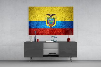 Glass wall art displaying Ecuador's flag with yellow, blue, and red horizontal stripes and central coat of arms, mounted above gray media console.