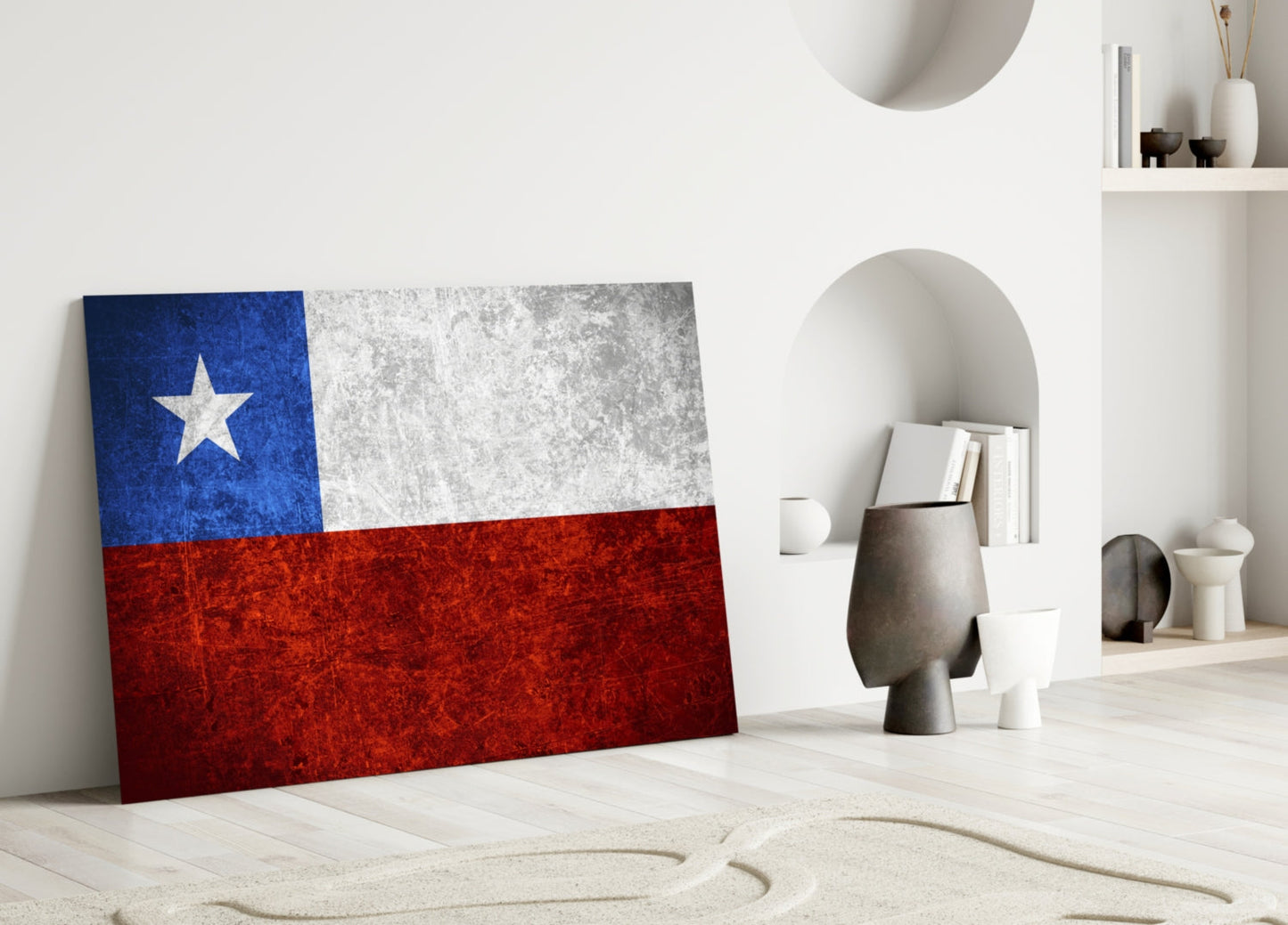 Chilean flag glass wall art leaning against white wall in minimalist interior with decorative objects and shelving.