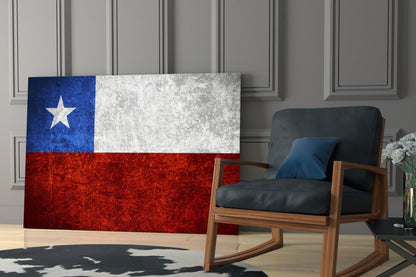 Chilean flag glass wall art displayed in a modern living room beside a wooden rocking chair with black leather cushions.