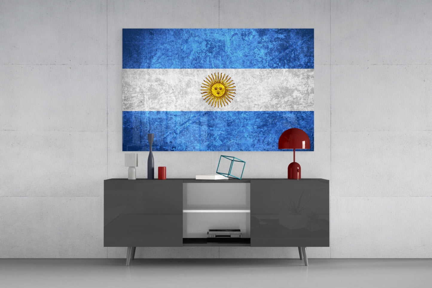 Argentina flag glass wall art hanging above gray media console with decorative objects in modern interior setting.