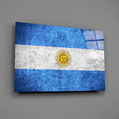 Argentine flag glass wall art displayed at an angle, showing blue and white horizontal stripes with a golden sun emblem.