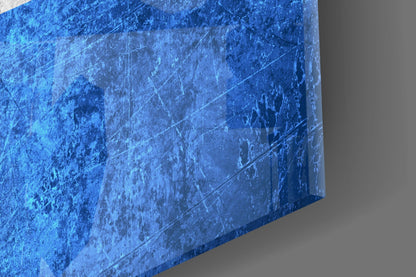 Close-up angled view of textured blue glass wall art with scratched surface and light reflections.