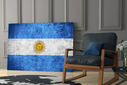 Argentine flag glass art leaning against wall beside wooden rocking chair in modern interior.