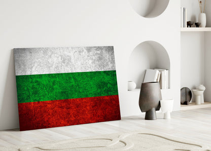 Bulgarian flag glass wall art leaning against white wall in minimalist interior with decorative objects.