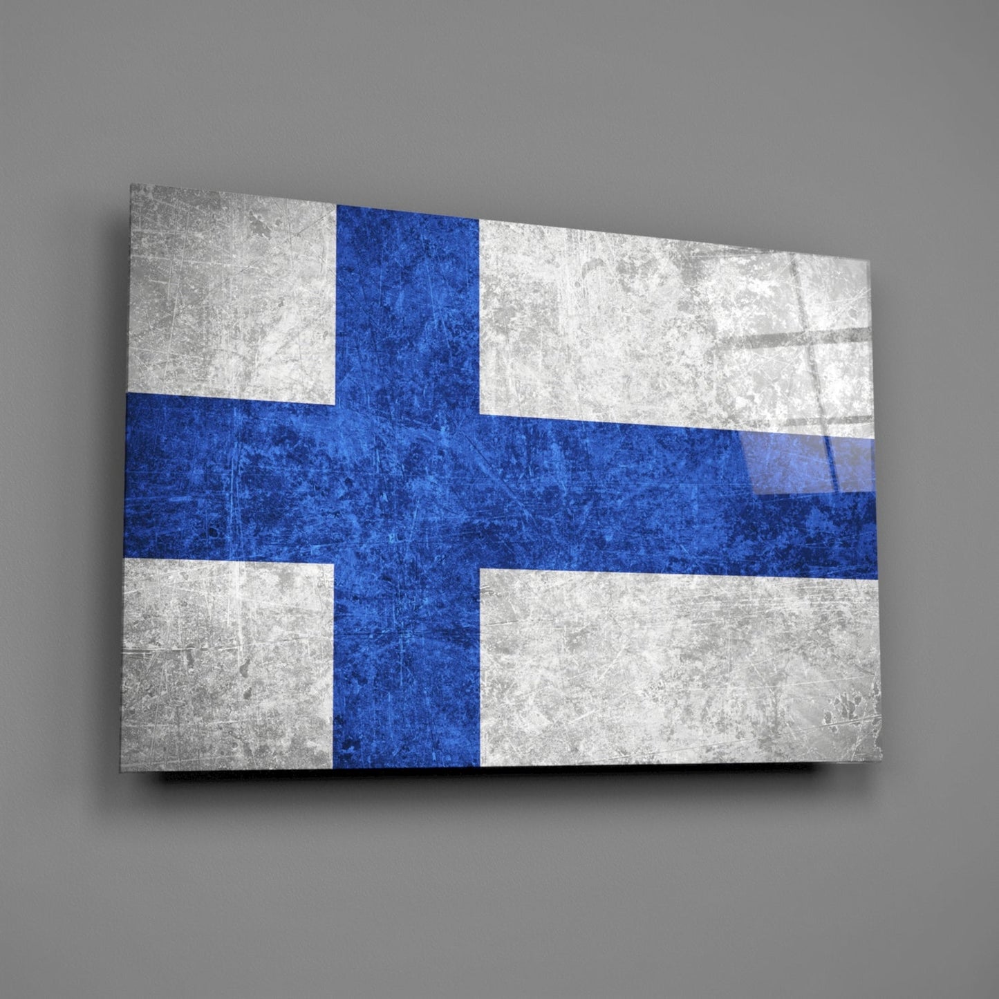 Finland flag glass wall art displayed at an angle, showing blue cross on white background with textured surface.