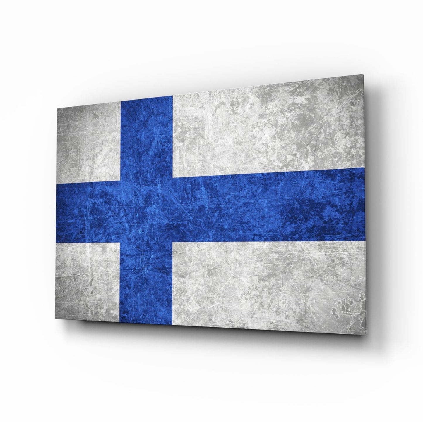 Finnish flag glass wall art displayed at an angle, showing blue cross on white distressed background with shadow.