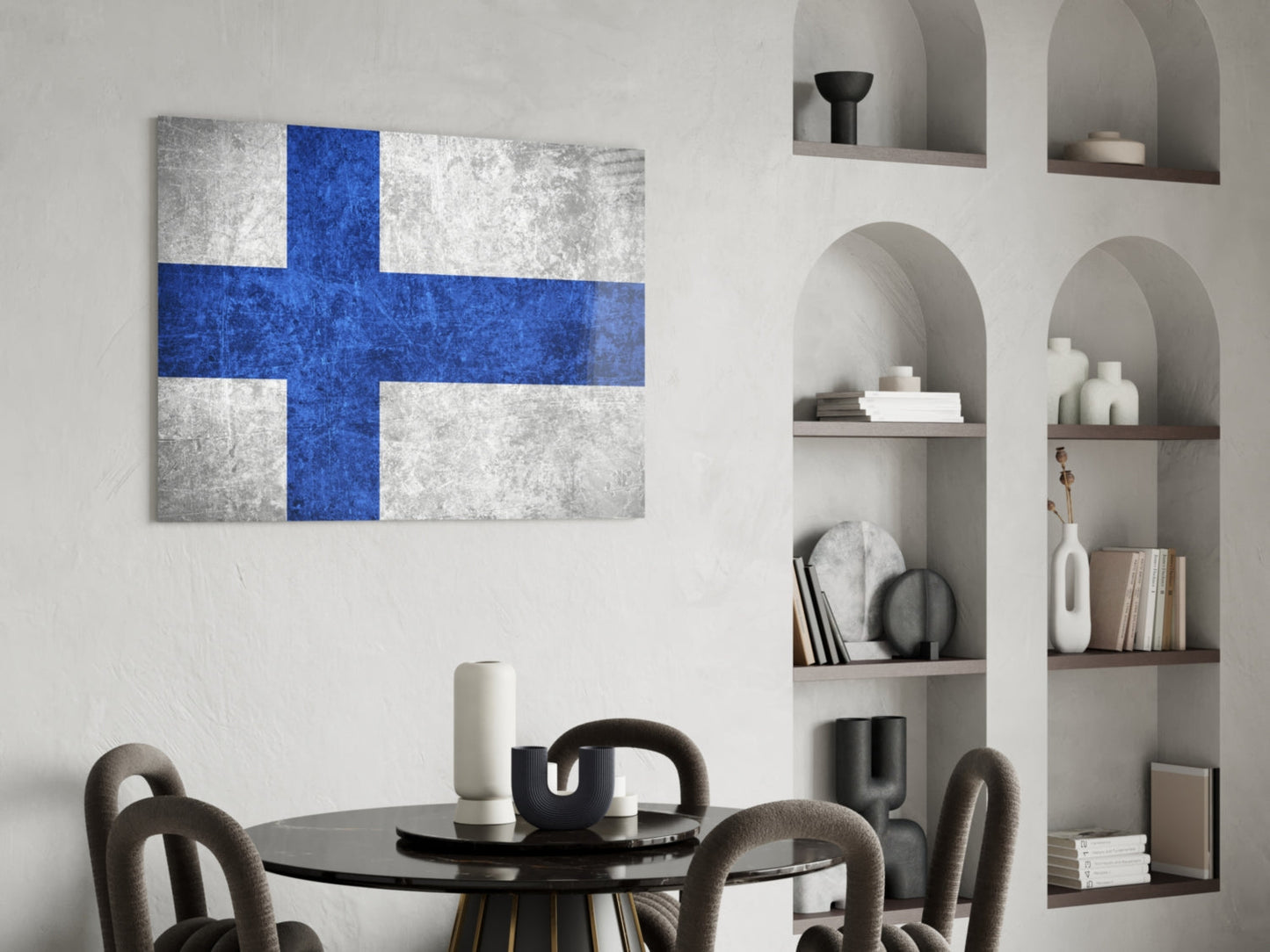 Finnish flag glass wall art with blue cross on white background displayed above black round dining table with gray chairs.