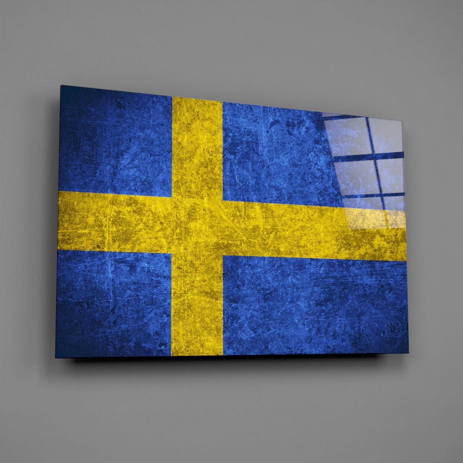 Swedish flag glass wall art panel displayed at an angle, showing blue and yellow cross design with textured surface and shadow.