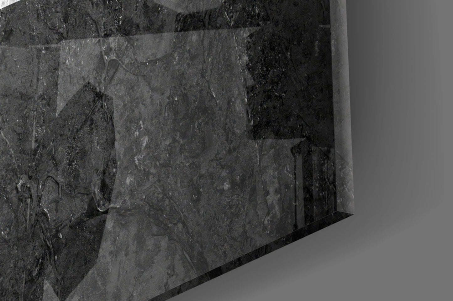Close-up angled view of textured dark gray glass surface with subtle surface details and reflections.