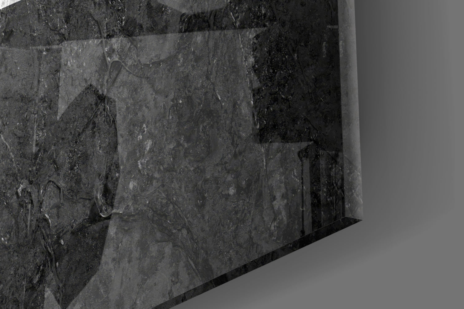 Close-up angled view of textured dark gray glass surface with subtle surface details and reflections.