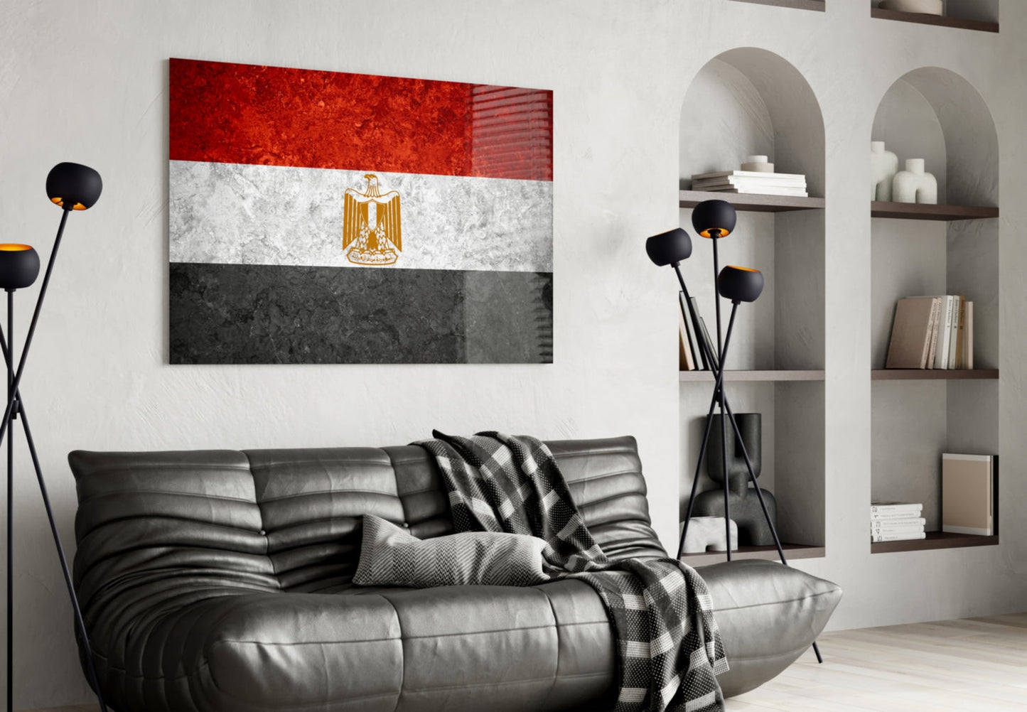 Egyptian flag glass wall art displaying red, white, and black horizontal stripes with gold eagle emblem, hung above black leather sofa in modern living room.