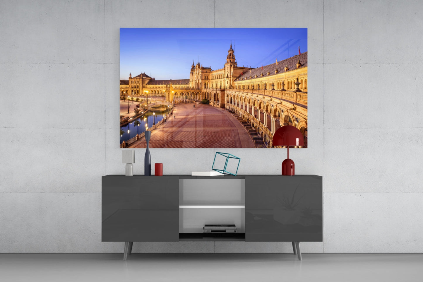 Sevilla Glass Wall Art displaying illuminated golden architecture mounted above dark gray media console with decorative accessories.