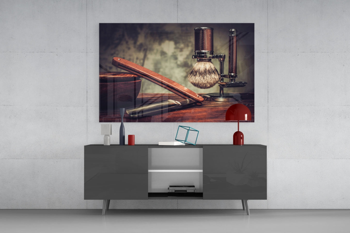 Vintage shave glass wall art displayed above gray media console, showing wooden straight razor, brush, and stand in warm tones.