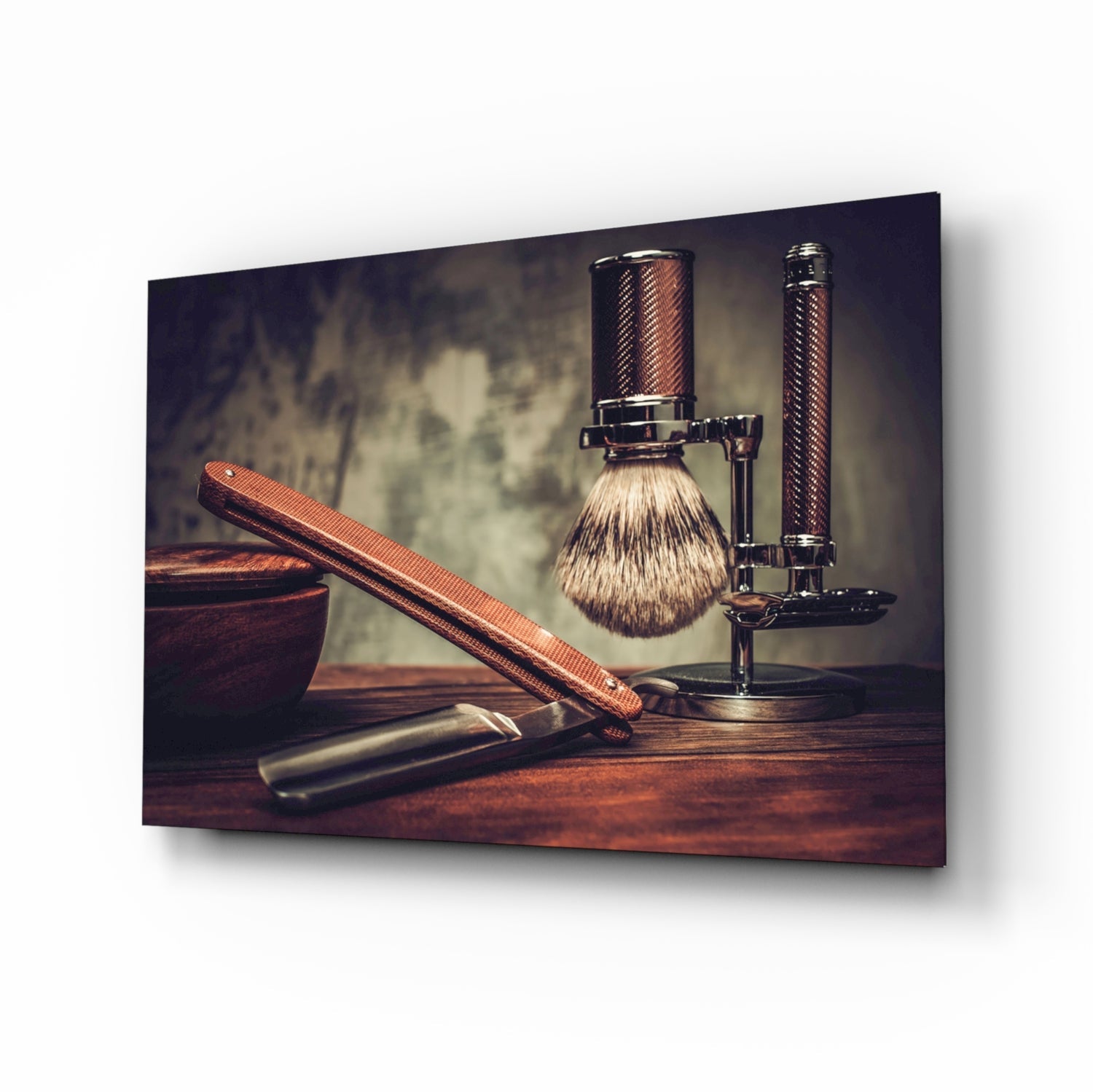 Vintage shaving tools arranged on wooden surface including brush, straight razor, and stand against textured neutral background.