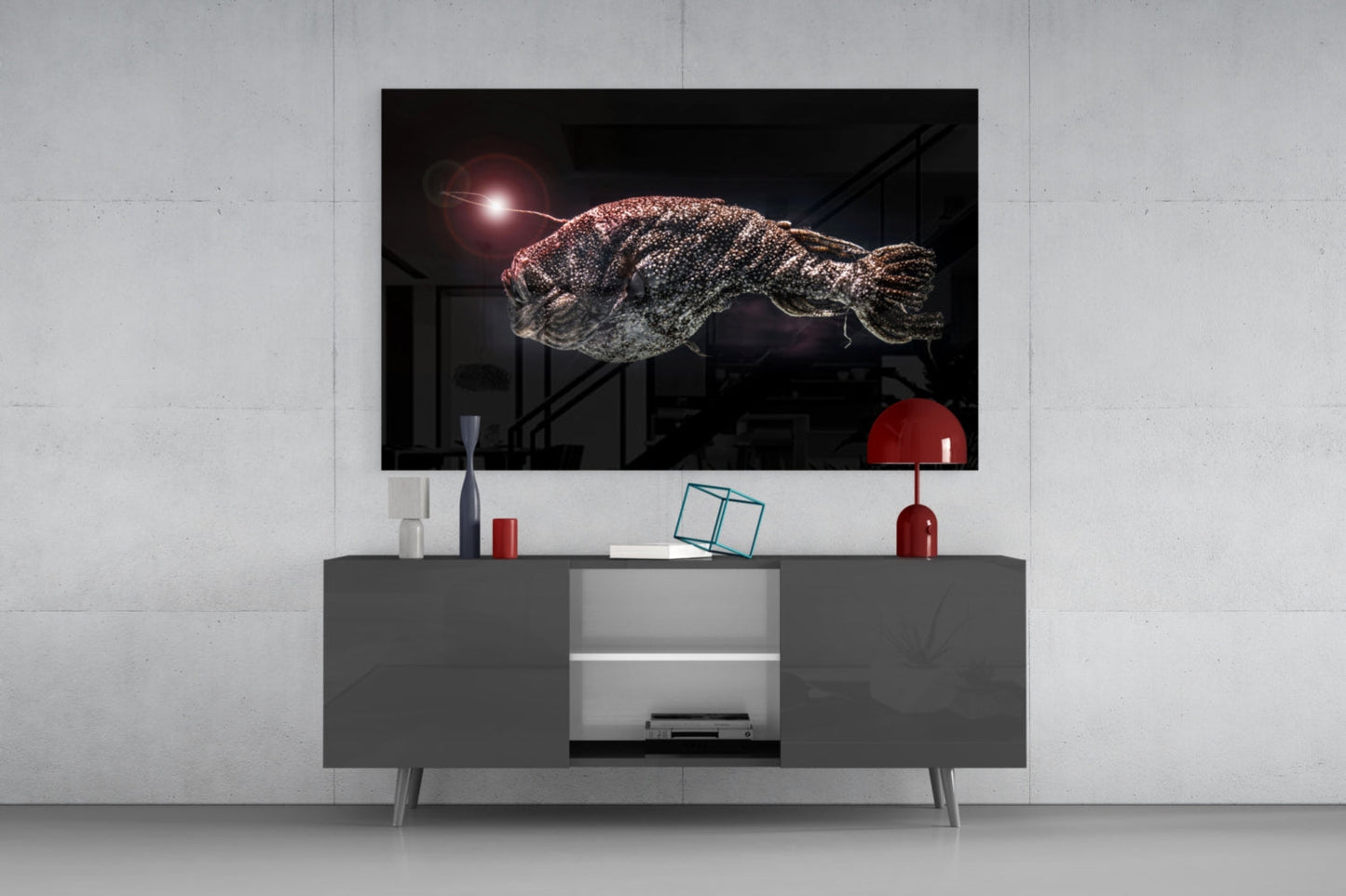 Deepsea fish glass wall art mounted above gray media console, displaying textured fish with glowing light source against dark background.