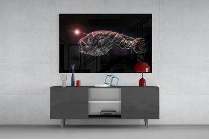 Deepsea fish glass wall art mounted above gray media console, displaying textured fish with glowing light source against dark background.