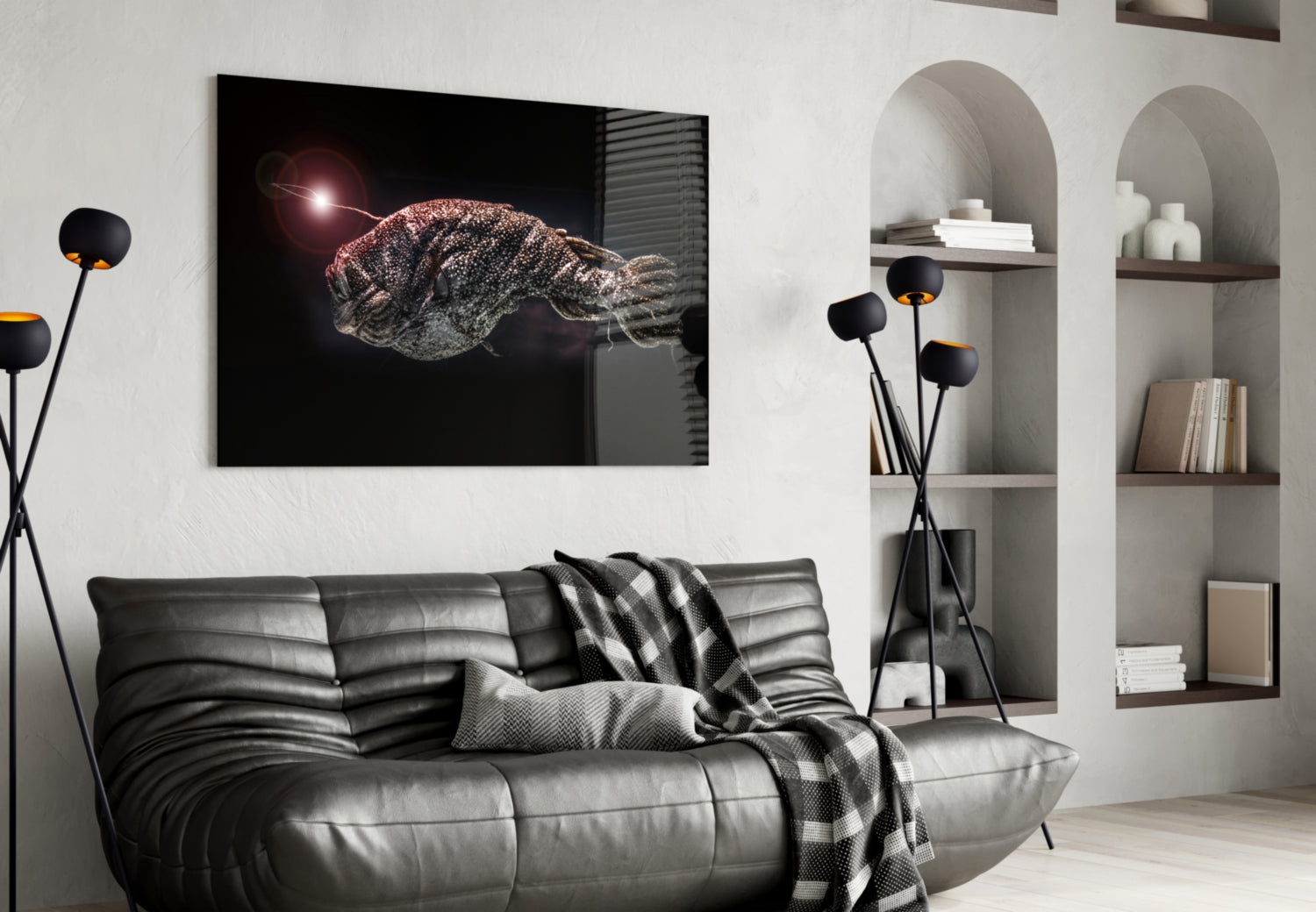 Black framed glass wall art depicting a glowing deep-sea fish displayed above a gray leather sofa in a modern living room.