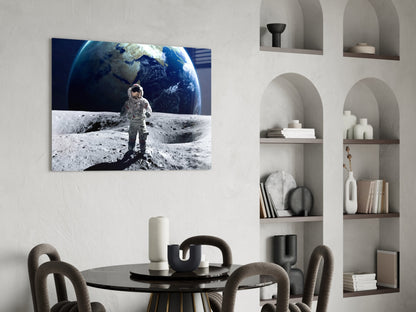 Astronaut in spacesuit standing on lunar surface with Earth rising in background, displayed as horizontal glass wall art above dining table.