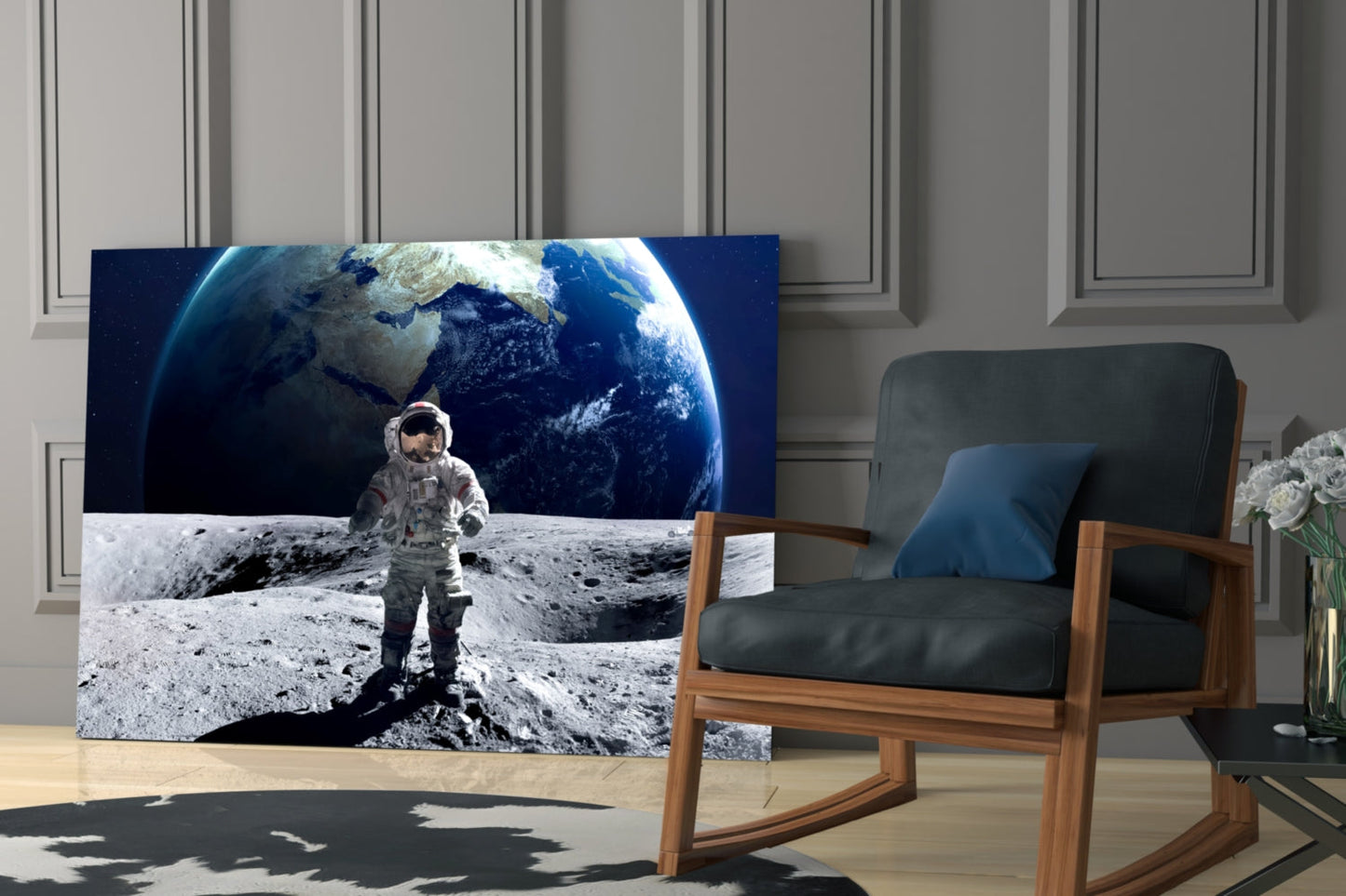 Glass wall art depicting an astronaut on the lunar surface with Earth in the background, displayed in a modern interior setting beside a wooden chair.