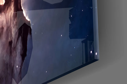 Glass wall art panel displaying deep blue and purple nebula clouds with white starlight particles, installed on white wall.