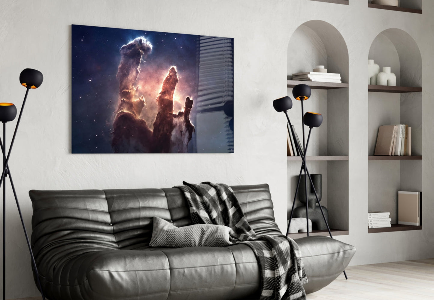 Space Clouds Glass Wall Art displaying glowing nebula pillars in deep blue and gold tones, mounted above a gray leather sofa in a modern living room setting.