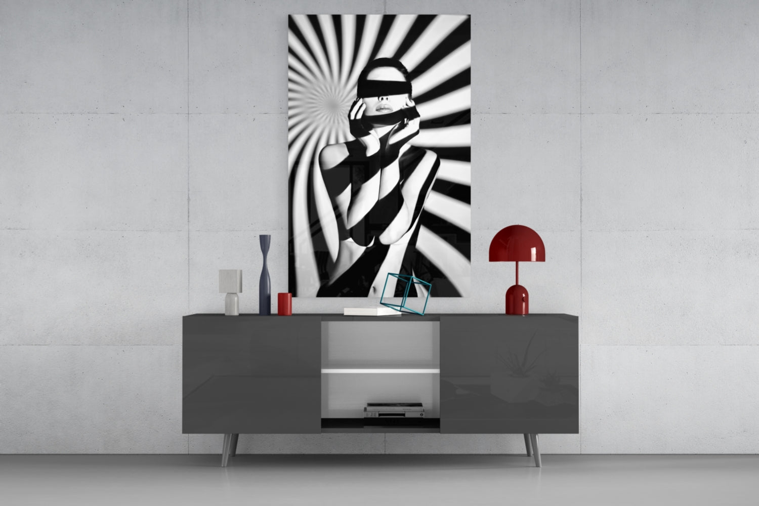 Black and white striped wall art featuring a blindfolded figure displayed above a gray media console with red decorative accessories.