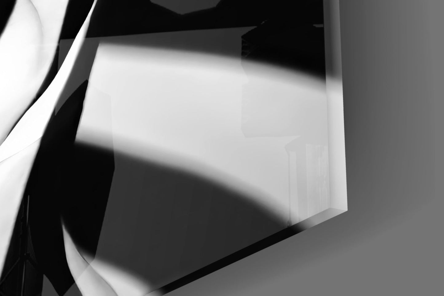 Abstract black and white glass wall art with geometric planes and dramatic shadows cast across white surface.