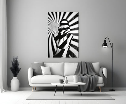 Black and white glass wall art depicting a censored figure with radiating stripes, displayed above a white sofa in a minimalist living room.