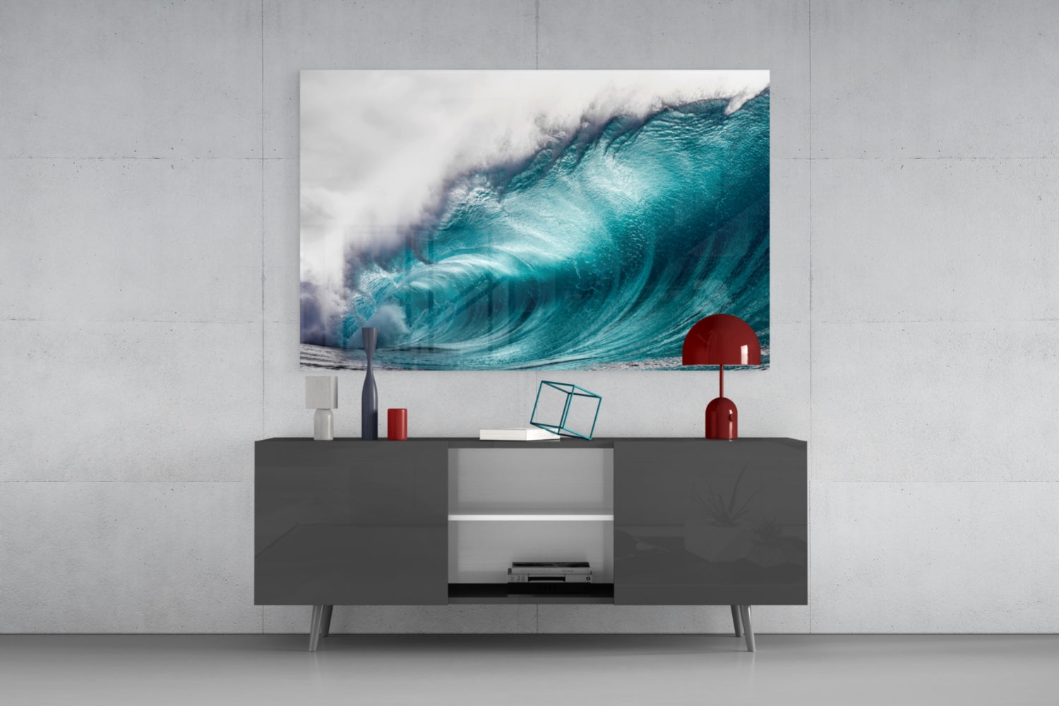 Turquoise wave glass wall art displaying a crashing ocean wave with white foam, mounted above a dark grey media console with red decorative accessories.