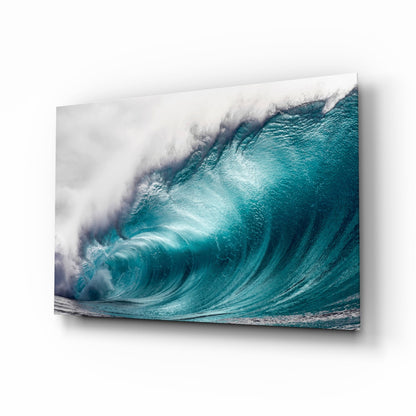 Turquoise ocean wave with white foam crest captured on glass wall art displayed at an angle.