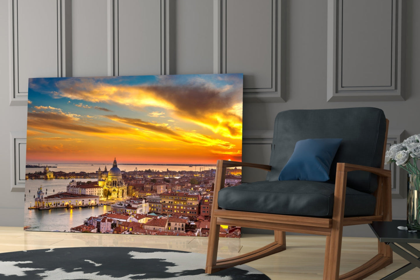 Sunset in Venice glass wall art displayed on floor leaning against wall beside wooden chair in modern interior.