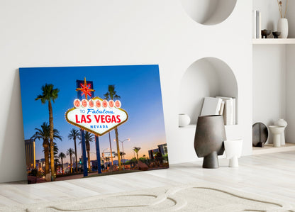 Las Vegas welcome sign glass wall art leaning against white wall in minimalist interior setting.