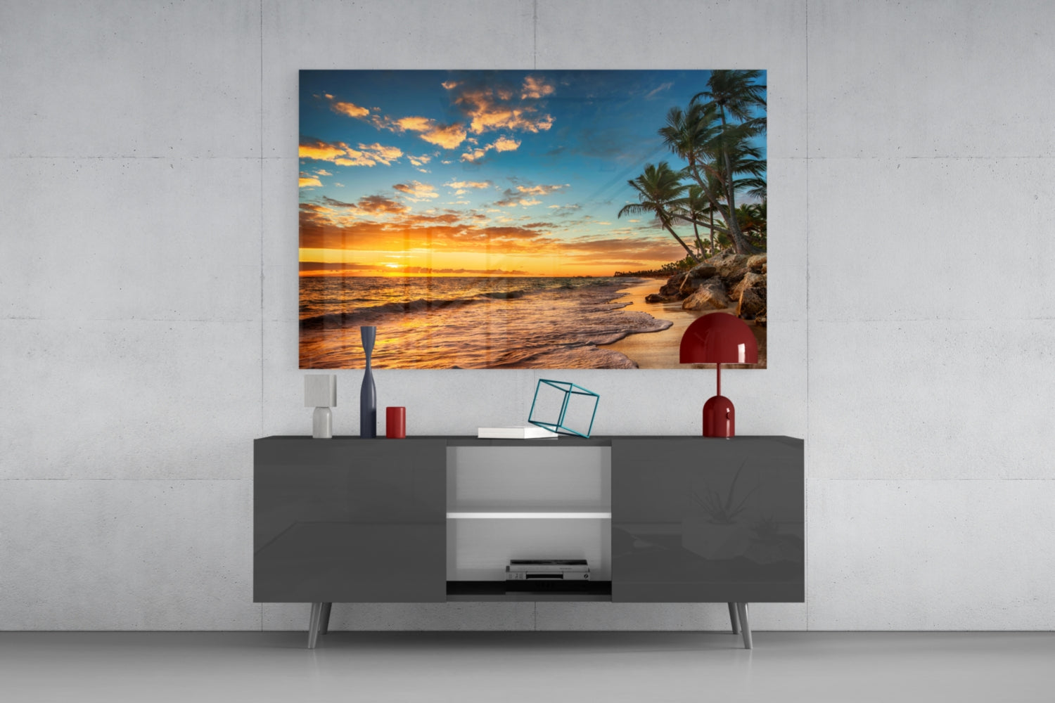 Beach Cruise glass wall art displaying a tropical sunset with palm trees mounted above a dark gray media console in a modern living room setting.