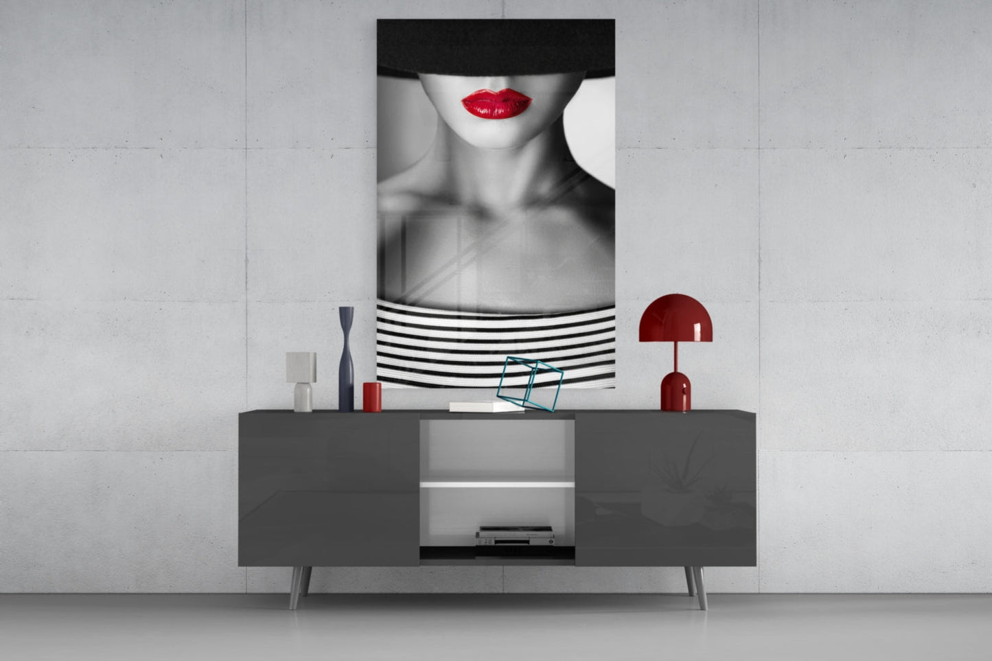 Modern living room display featuring black and white portrait glass art with red lips above grey sideboard with red accents.