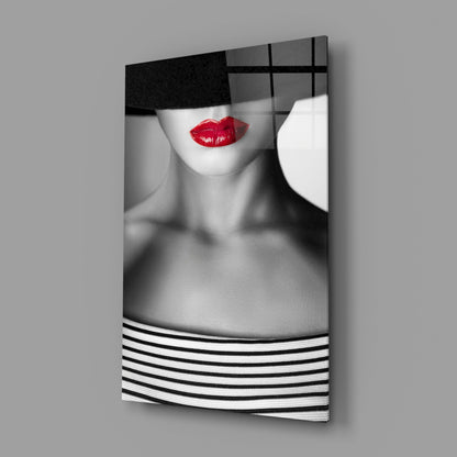 Modern glass wall art displaying black and white portrait with bold red lips, geometric patterns, and grid design mounted at angle.