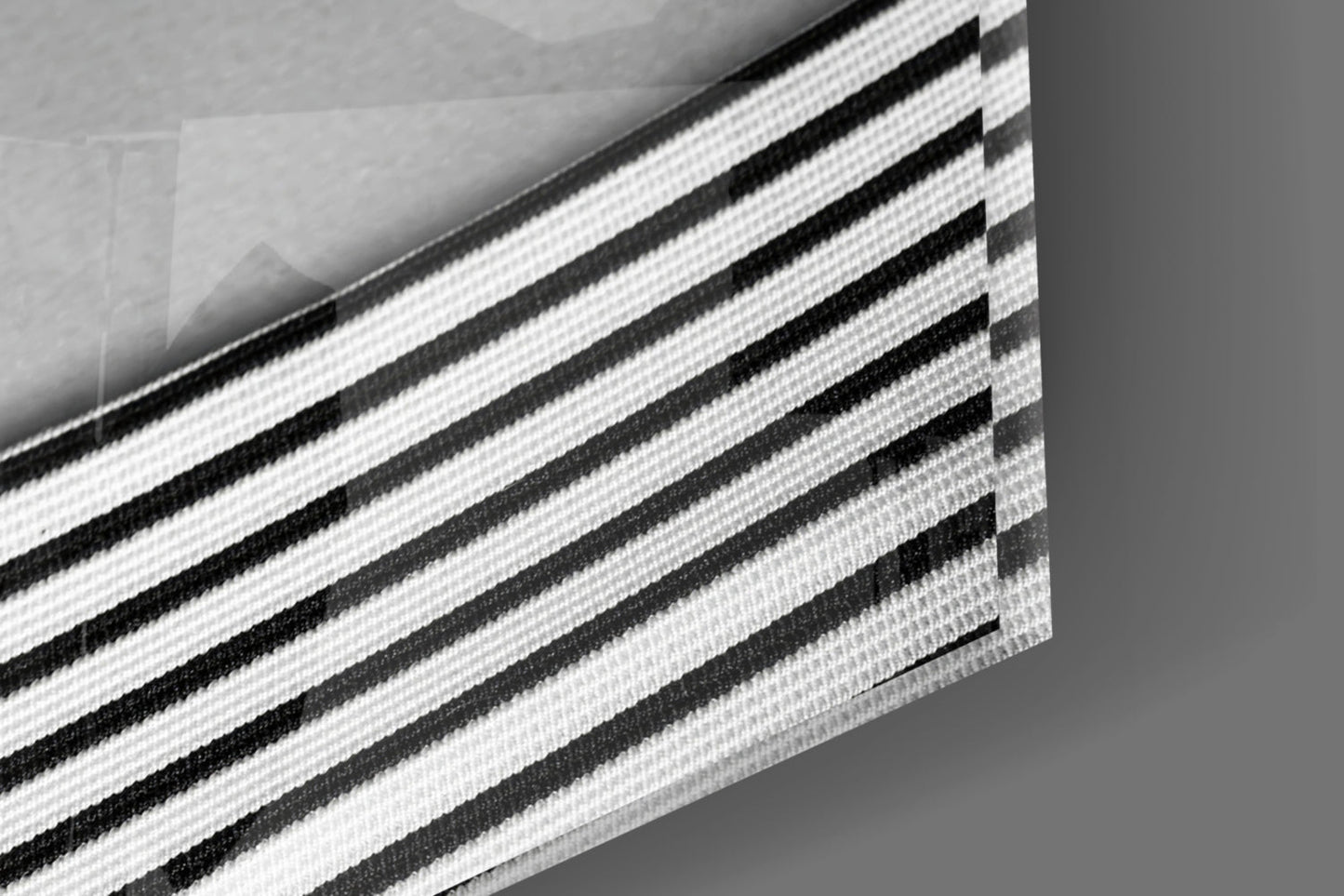 Close-up detail of layered black and white striped fabric or material with textured weave pattern.