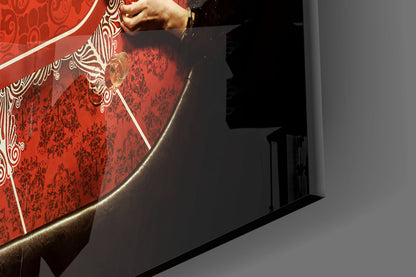 Close-up of red glass wall art with ornate white and gold decorative borders and damask patterns, hand touching upper edge.